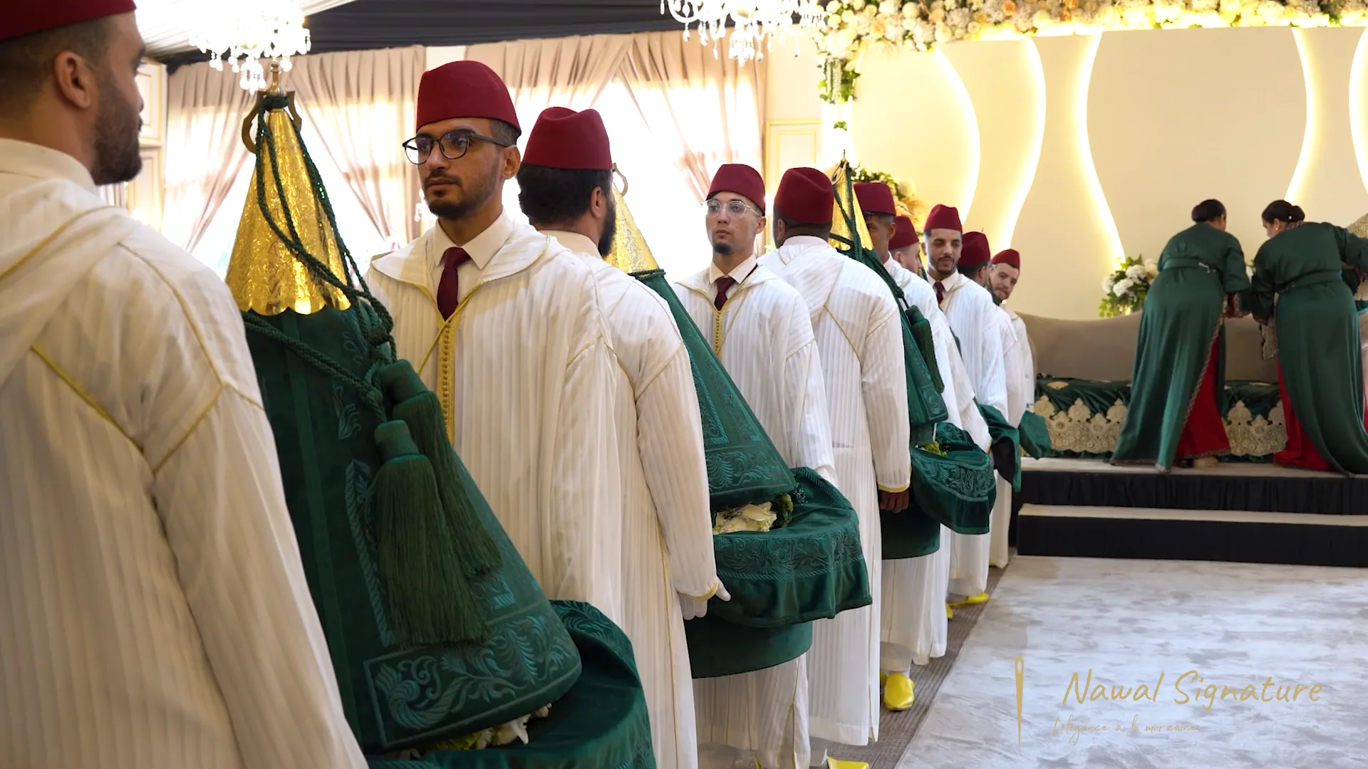 Porteurs alignés avec leurs Tyafer verts, coiffés de fez